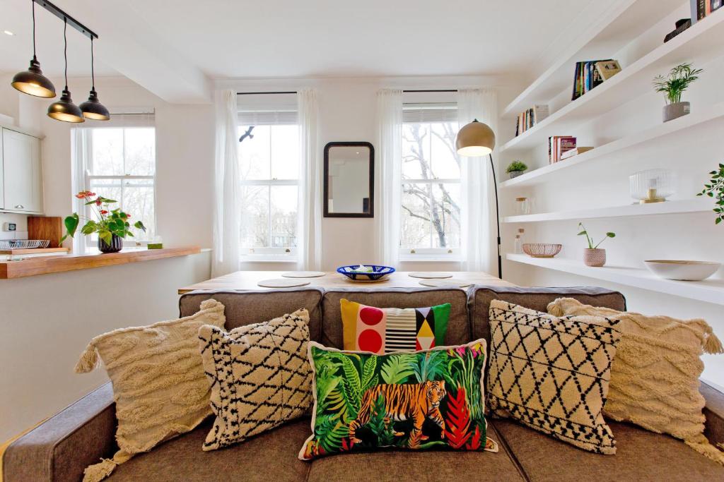 ein Wohnzimmer mit einem Sofa und Kissen in der Unterkunft 4 Bed Duplex Garden Views in London