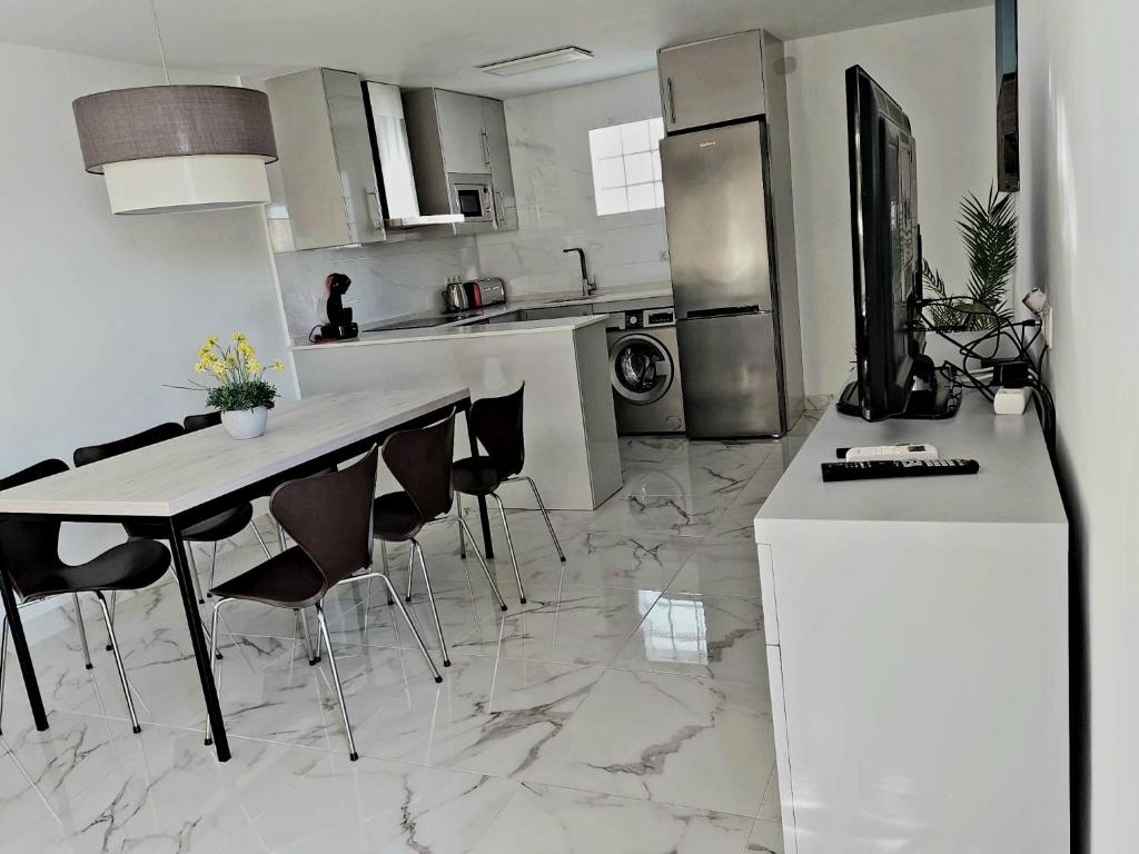 een keuken met een aanrecht en een tafel met stoelen bij Villa Musica in Torremolinos