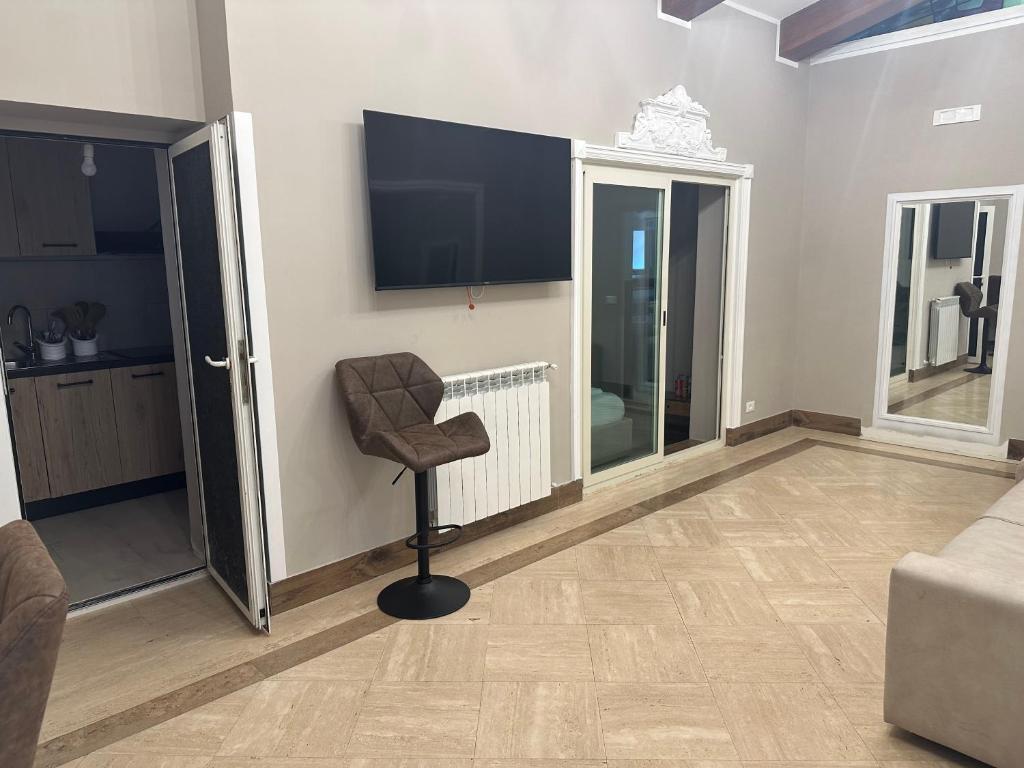 een woonkamer met een stoel en een flatscreen-tv bij Imperial Maison Rome in Rome