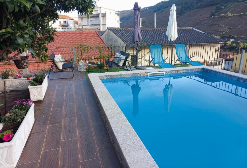 a swimming pool with blue water in a yard at Casa Nunes in Pinhão