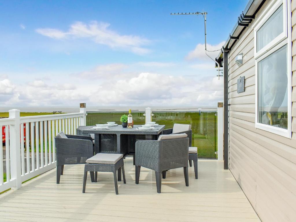 a patio with a table and chairs on a deck at Seaview 1 in Heysham