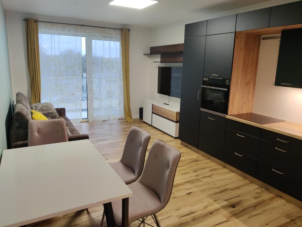 uma cozinha com mesa e cadeiras num quarto em DOMAR APARTAMENT em Breslávia