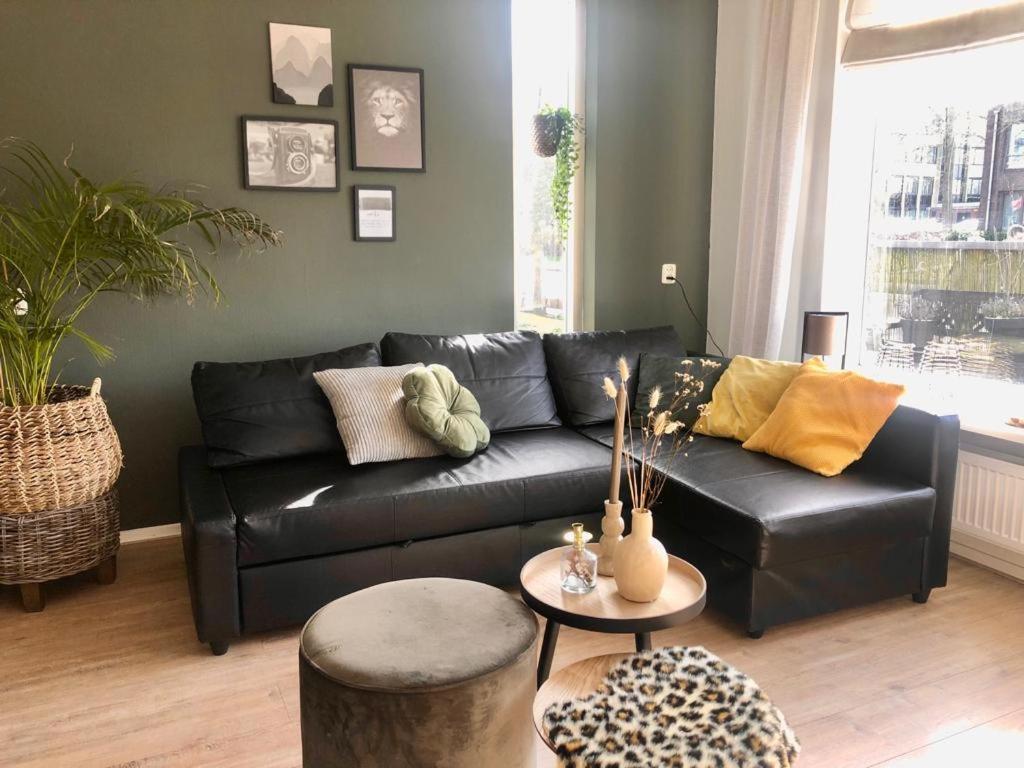 a living room with a black leather couch at Cramer's Corner in Hardenberg