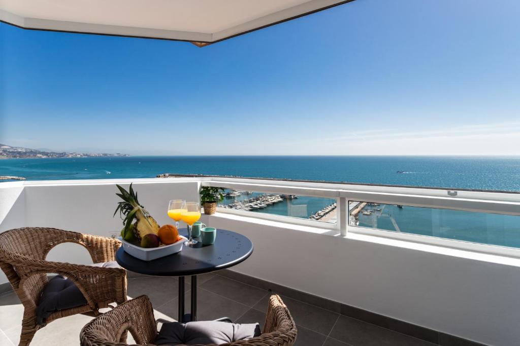 uma varanda com uma mesa e vista para o oceano em Sur Suites Palmeras 10 em Fuengirola