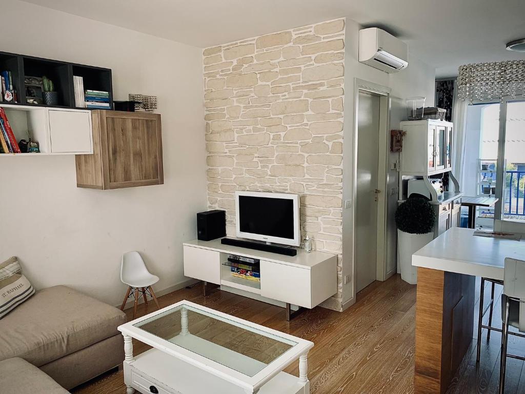 ein Wohnzimmer mit einem Sofa und einem TV auf dem Tisch in der Unterkunft Appartamento incantevole a Misano Adriatico in Misano Adriatico
