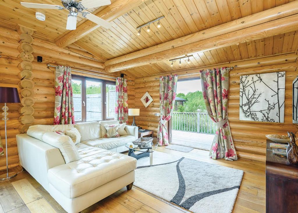 a living room with a white couch and a table at Weybread Lakes Lodges in Brockdish