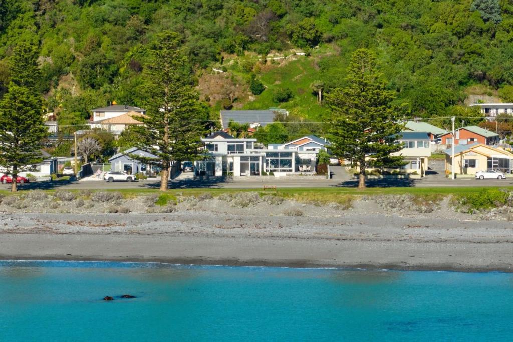 Blick auf einen Strand mit Häusern und Bäumen in der Unterkunft Shearwater Apartments in Kaikoura