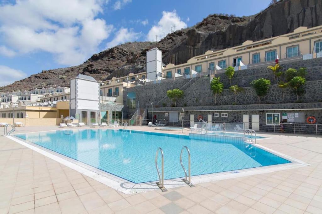 a large swimming pool in front of a building at Las Brisas de Puerto Rico in Mogán