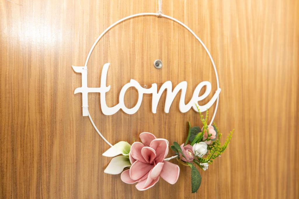 een thuisbord hangend aan een muur met bloemen bij Ferienwohnung Mark in Villingen-Schwenningen