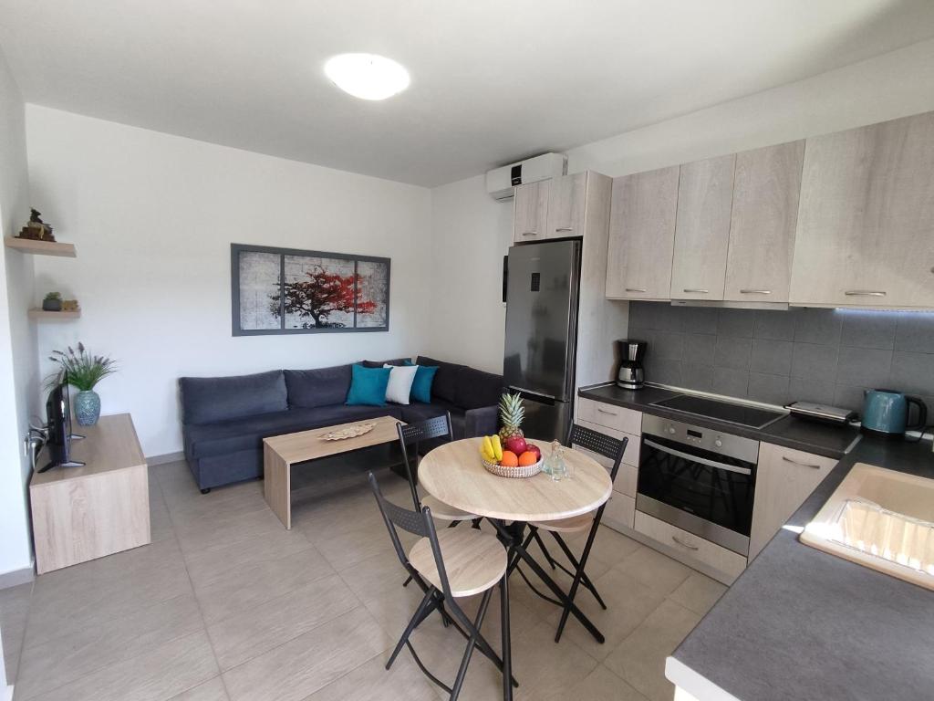 uma cozinha e sala de estar com uma mesa e um sofá em Psaromoura Apartment 2 em Agia Pelagia