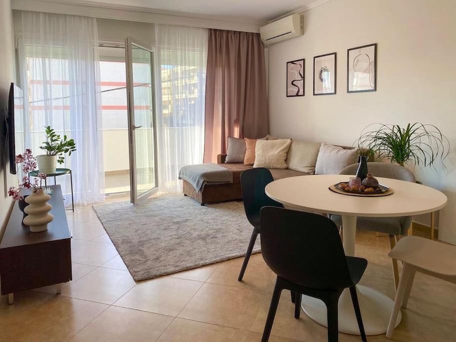 a living room with a couch and a table with chairs at East Coast Senses in Thessaloniki