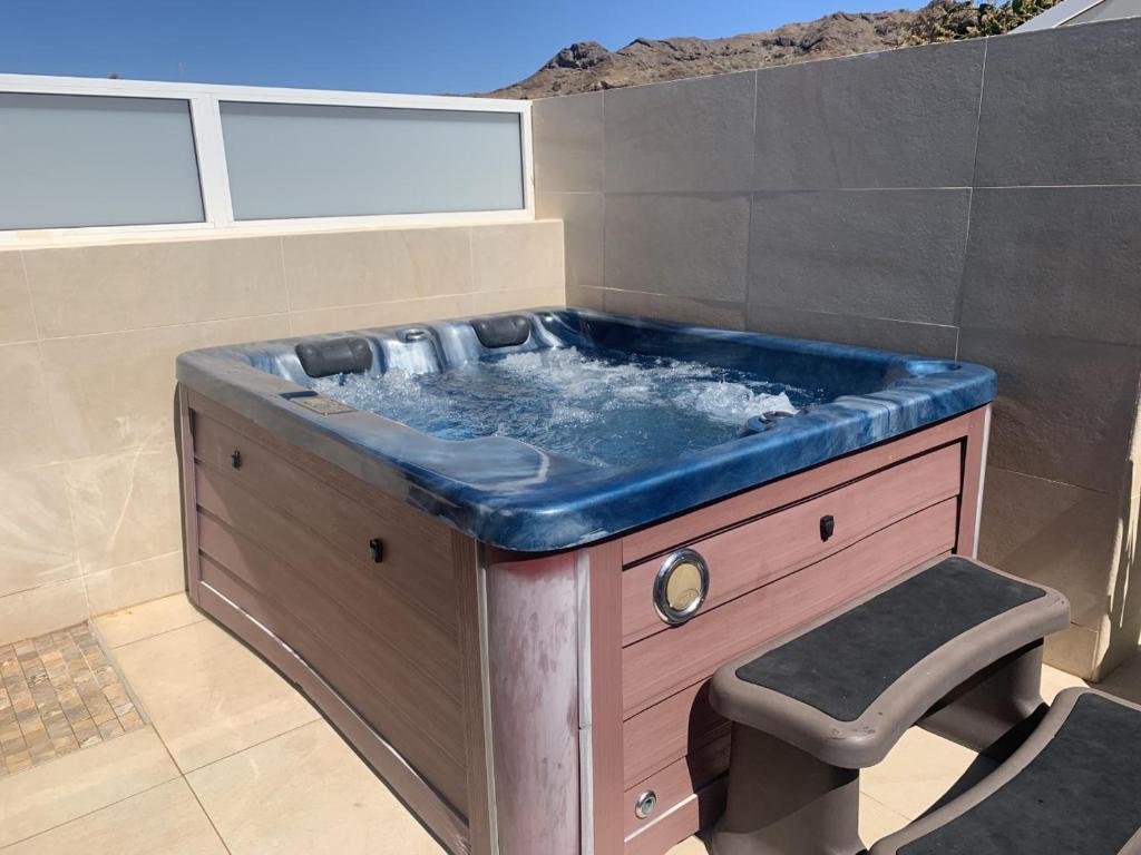 y baño con bañera de hidromasaje y blusa azul. en Bungalow el Valle in Puerto Rico with Jacuzzi, en Puerto Rico de Gran Canaria