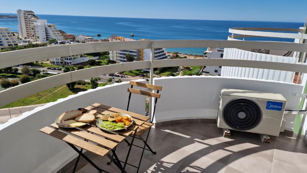 una mesa con un plato de comida y un televisor en el balcón en Sunsetview en Portimão