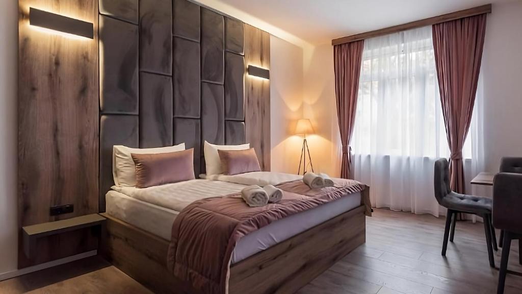 a bedroom with a large bed with a padded headboard at Casa ARTEE Free Parking in Sarajevo