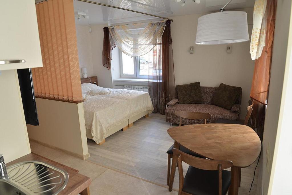 a bedroom with a bed and a table and a couch at Apartment Centrum in Narva