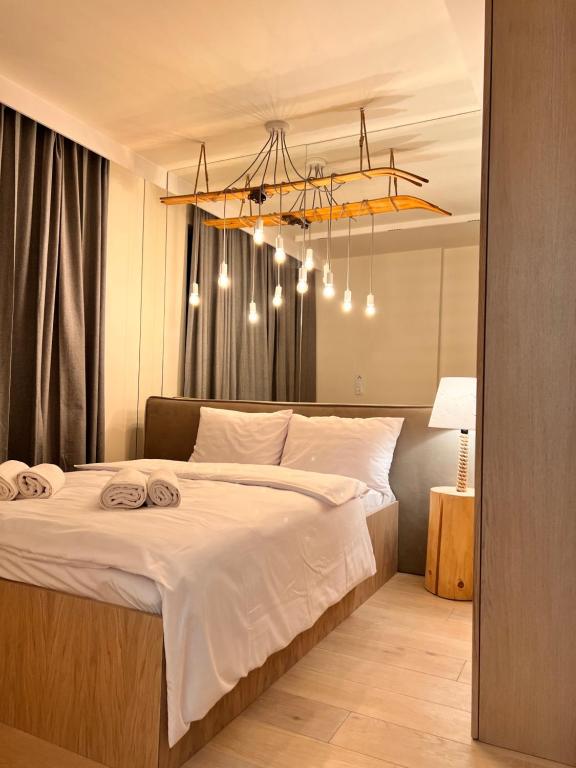 1 dormitorio con 1 cama blanca grande con lámpara de araña en Kryształ Górski apartament z sauną, en Szczyrk