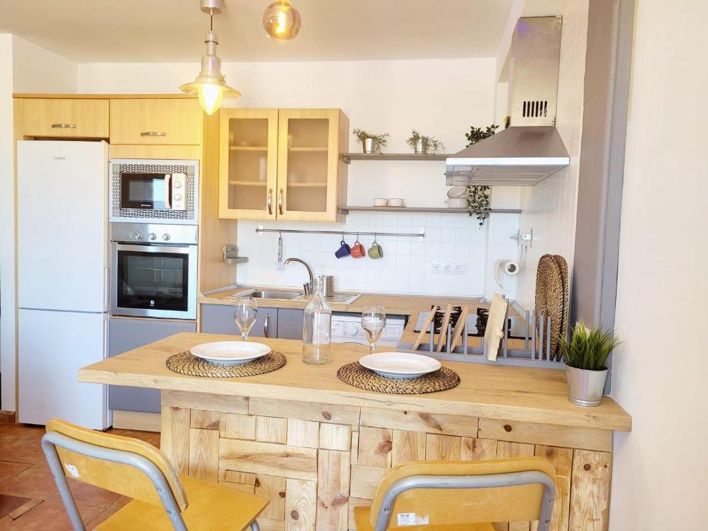 cocina con mesa de madera con sillas y fregadero en Casa Faro de Arinaga en Arinaga