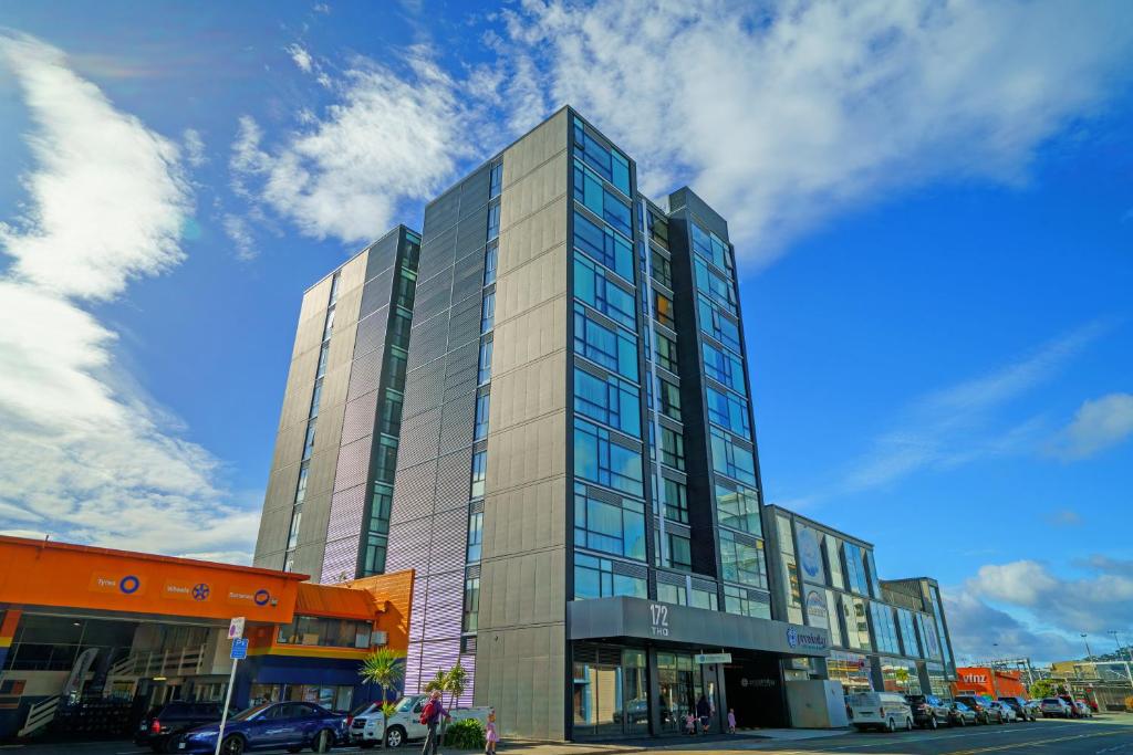 een hoog glazen gebouw in een stadsstraat bij The Sebel Wellington Thorndon in Wellington