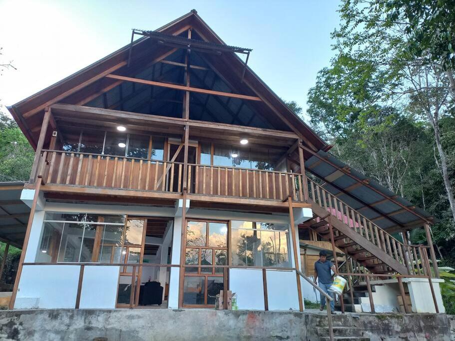 une maison construite avec un homme debout devant elle dans l'établissement Cabañas del bosque Don Efraín-La Merced, à La Merced