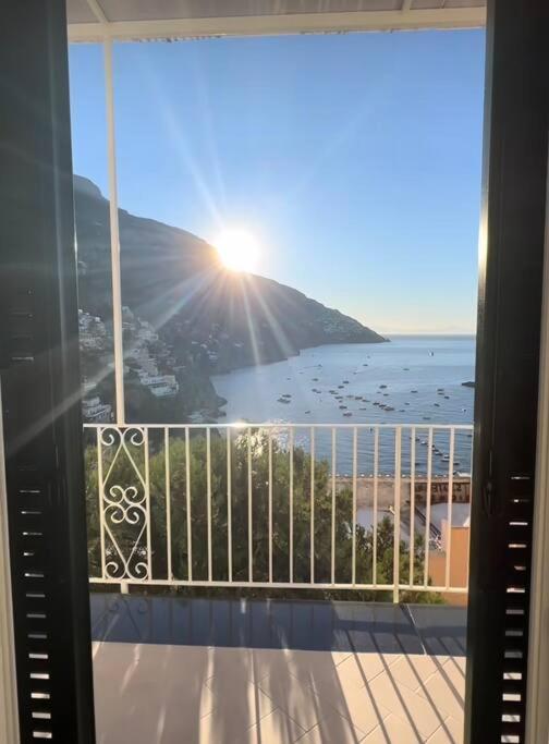 a balcony with a view of the beach and the sun at Queen View Apartment - No kitchen in Positano
