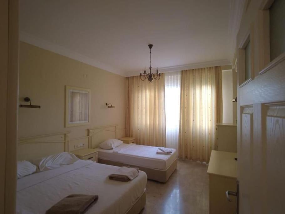 Cette chambre comprend 2 lits et une fenêtre. dans l'établissement goldcity yazlık daire alanya Türkiye, à Alanya