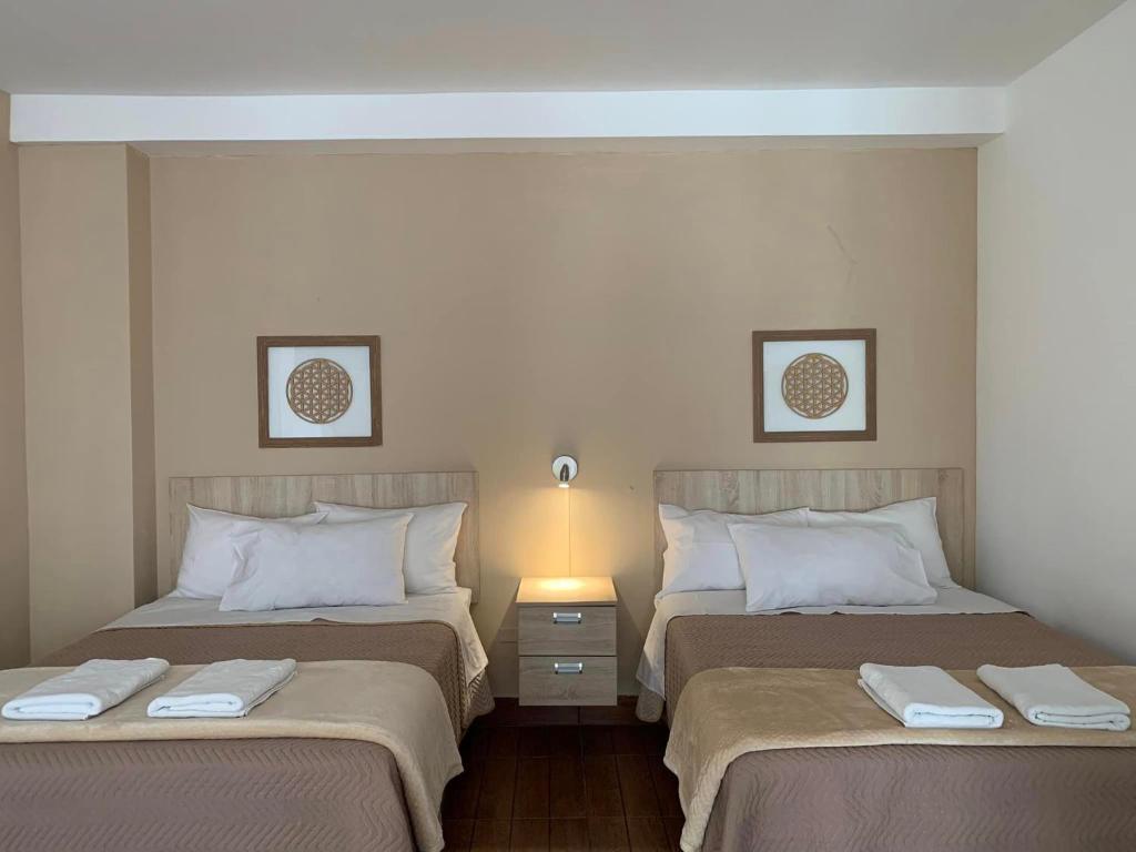 2 letti in camera d'albergo con asciugamani di Renace Suites a Tacna