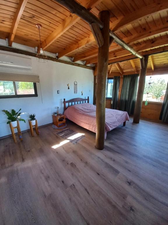 Un dormitorio con una cama grande en una habitación con techos de madera. en Espejos de monte en San Miguel del Monte