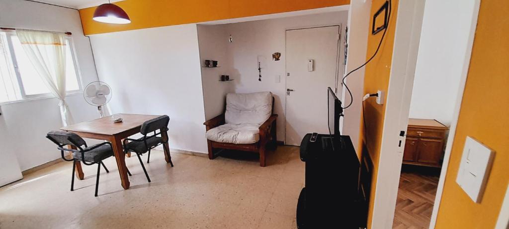una habitación con una mesa, una silla y una maleta en Live en Rosario