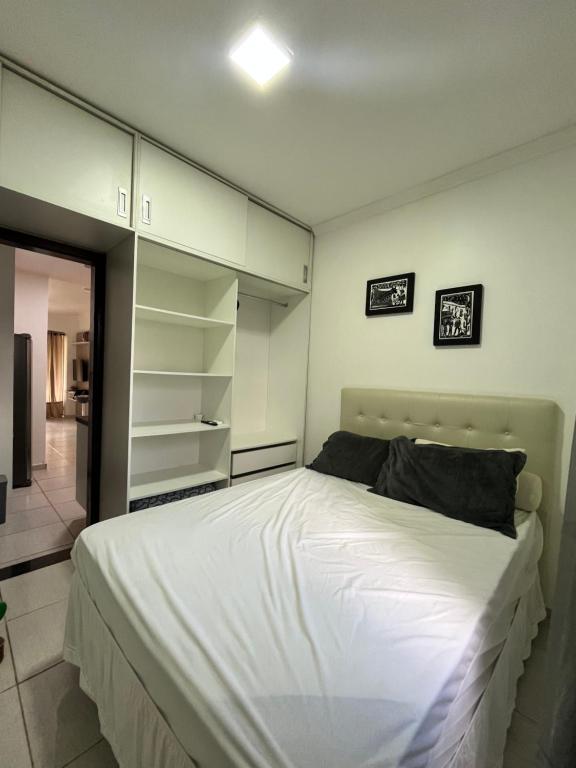 a bedroom with a large white bed and shelves at Winterville flat 307 in Gravatá