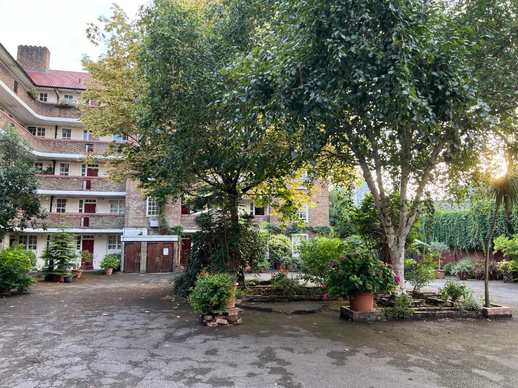 a courtyard with trees and plants in front of a building at Cosy London bedroom near Oval Station - shared bathroom in London