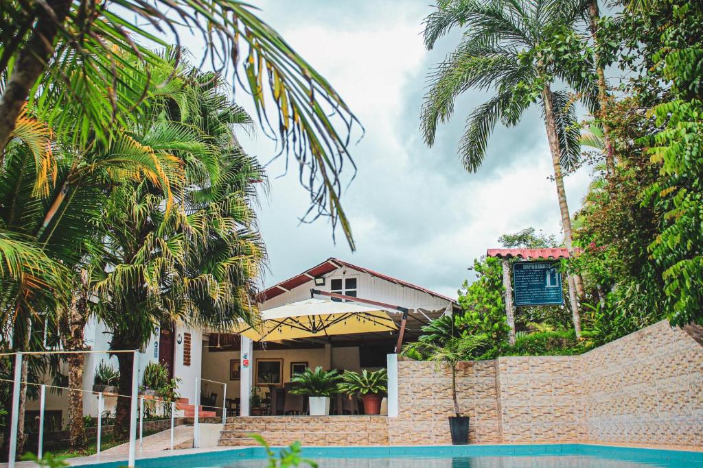 een huis met palmbomen en een zwembad bij Albergue Turístico Gstir in Pozuzo
