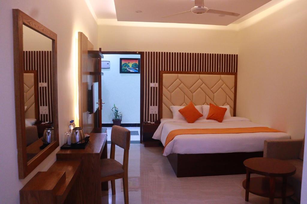 a bedroom with a bed and a desk and a mirror at Grand Castle Hotel & Resturant in Comilla