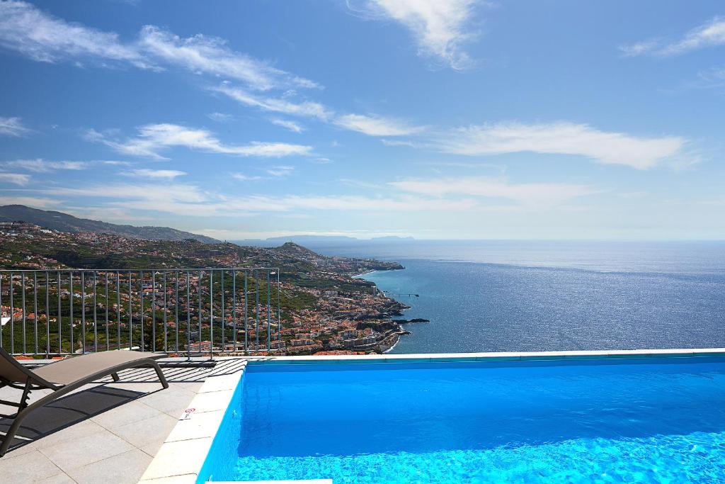 a swimming pool with a view of the ocean at Peak A Boo Private Heated Pool and Private Parking in Câmara de Lobos
