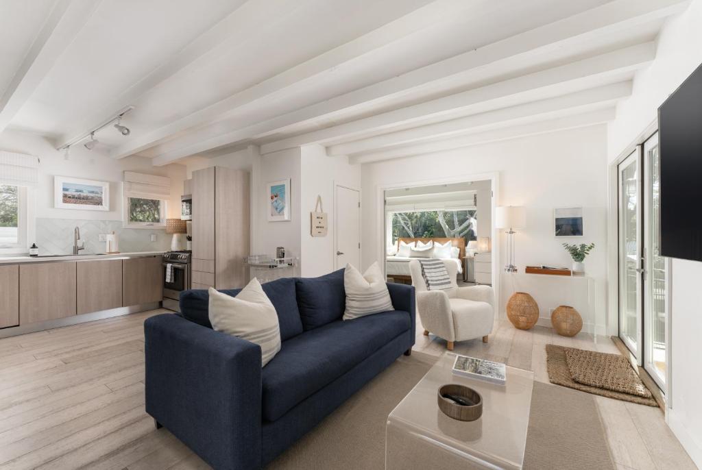 a living room with a blue couch and a kitchen at Palm Cottage in Montecito