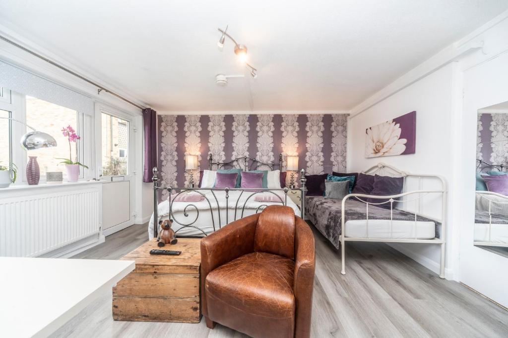 - une chambre avec un lit et une chaise dans l'établissement 11 Boutique studio apartment perfect for peaceful getaway, secluded garden, quiet location, à High Wycombe