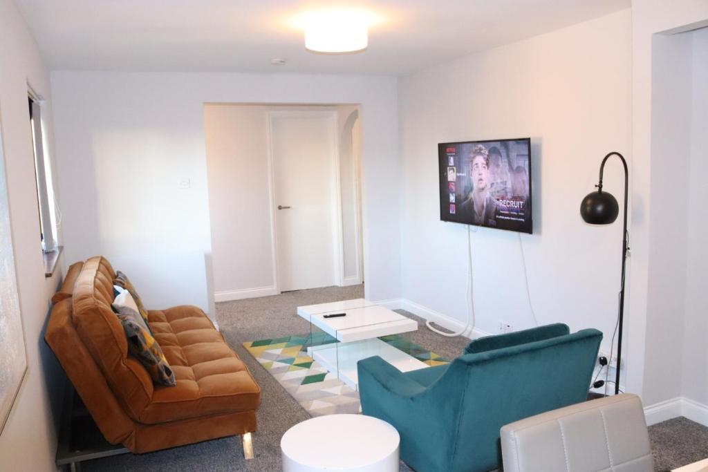 uma sala de estar com um sofá, cadeiras e uma mesa em Garland Modern Apartment with Private Garden & Parking Dartford 5 em Kent