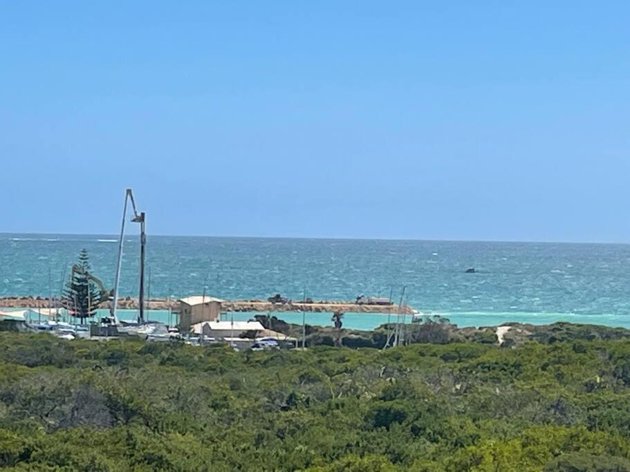 a view of the ocean with a windmill in the distance at Ocean Reef Retreat in Perth