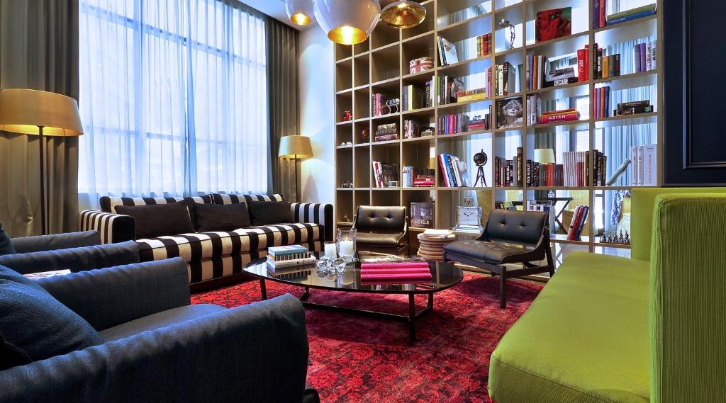 a living room with couches and a book shelf at Hotel Indigo Tel Aviv - Diamond District, an IHG Hotel in Tel Aviv