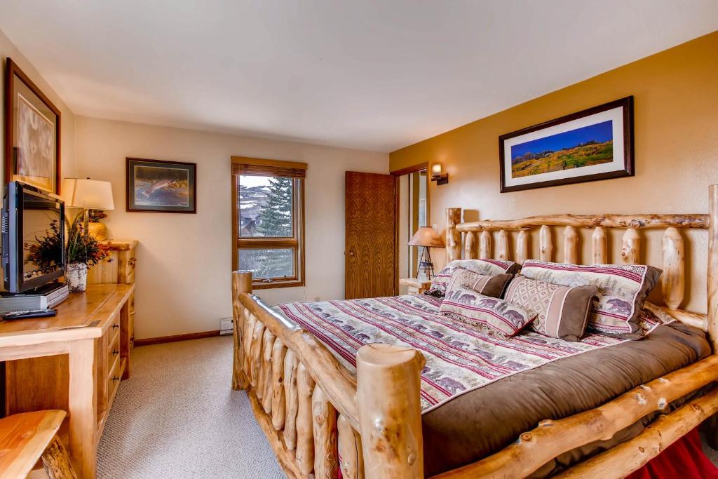 a bedroom with a wooden bed and a television at Rustic 3 Br Condominium Condo in Crested Butte