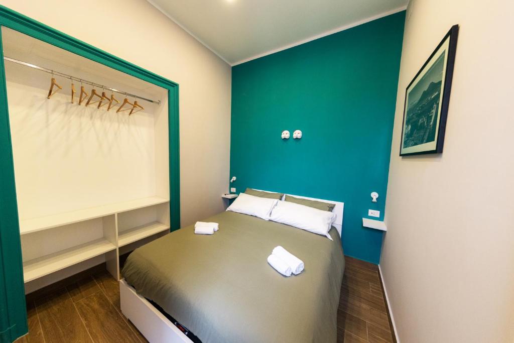 um quarto com uma cama com uma parede em tons de verde em A CASA DI PUPA GUEST HOUSE em Nápoles