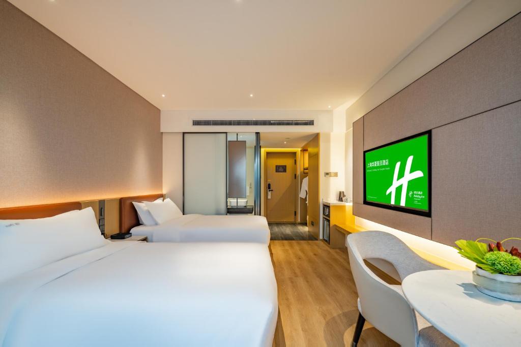 Postel nebo postele na pokoji v ubytování Holiday Inn Shanghai Huaxia by IHG - overlooking city scenery at Sky View Restaurant