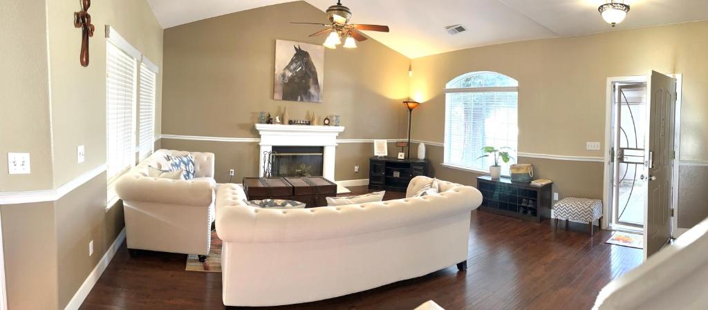 sala de estar con 2 sofás blancos y chimenea en Serenity, en Fresno