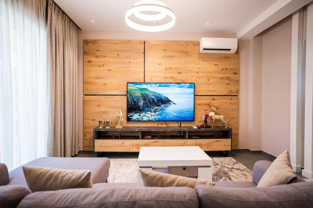 Vila Perla Gjiri Lalzit , Perla Resort في دوريس: غرفة معيشة مع أريكة وتلفزيون بشاشة مسطحة