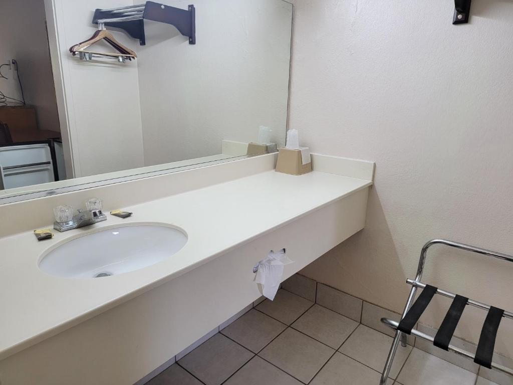 a bathroom with a sink and a mirror at Studio 9 Inn & Suites in Decatur