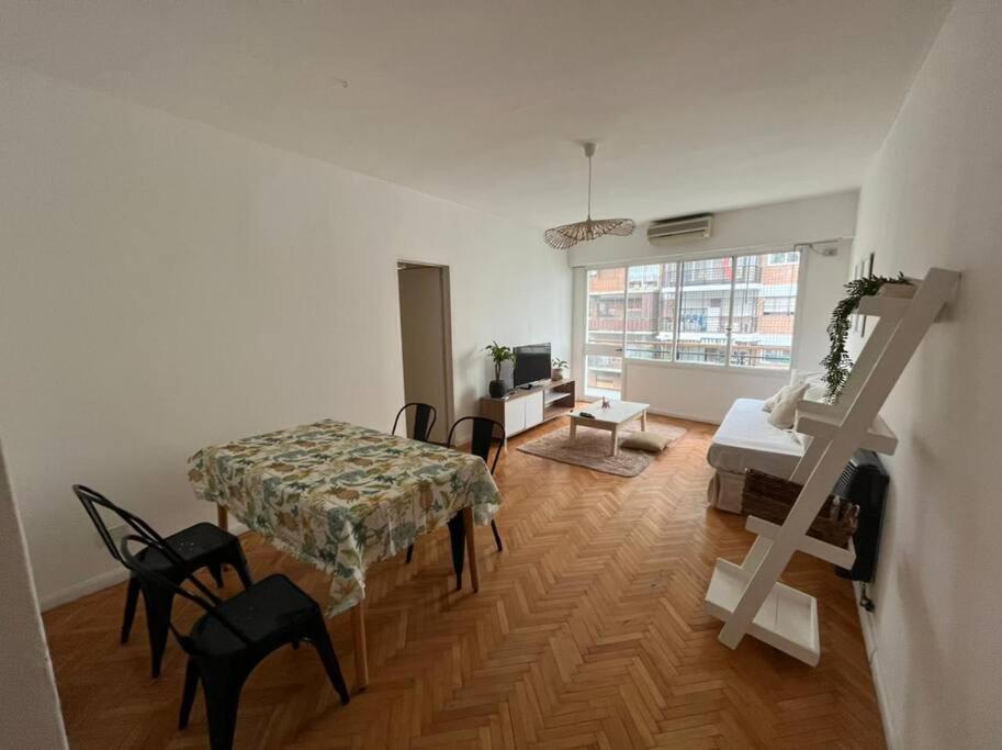 - un salon avec une table, des chaises et un bureau dans l'établissement Bright apartment in Palermo, à Buenos Aires