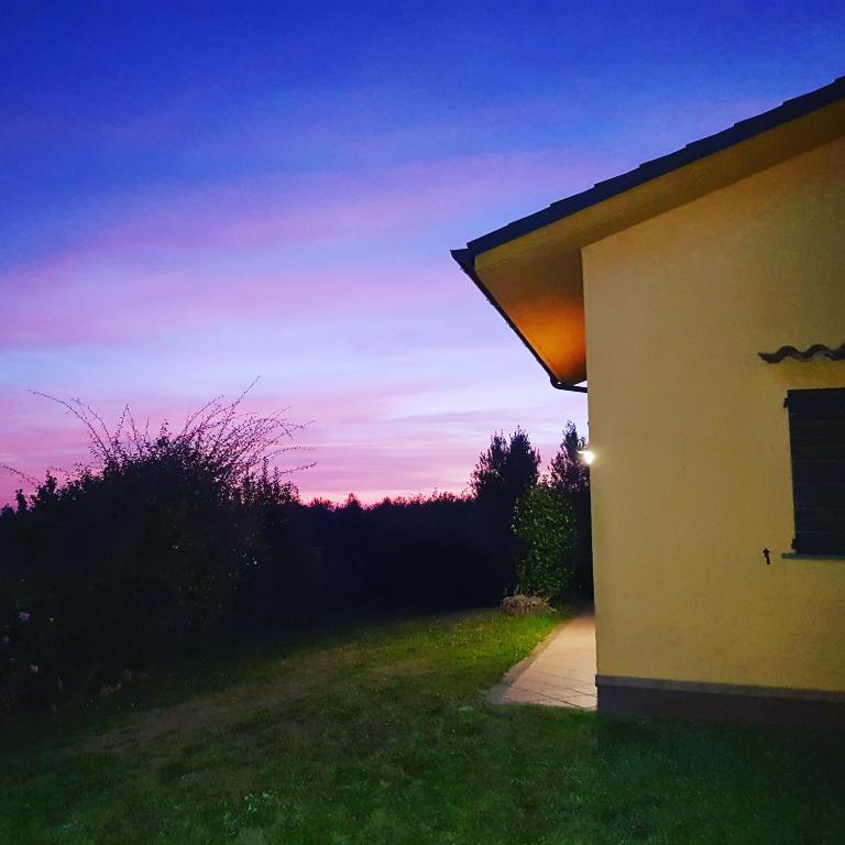 a building with a sunset in the background at Villa Oliva in Canino