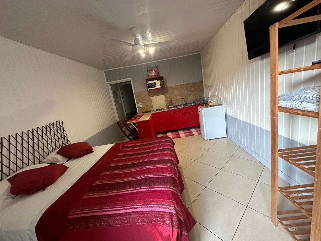 1 Schlafzimmer mit einem großen Bett und einer Küche in der Unterkunft B&B Tontouta in La Tontouta