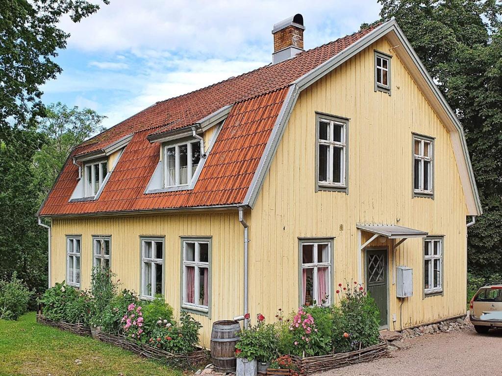 uma casa amarela com um telhado laranja em Holiday home FÄRGELANDA V em Färgelanda