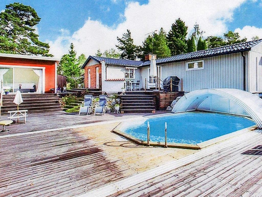 Holiday home NYNÄSHAMN في نينس هامن: منزل به مسبح على سطح خشبي