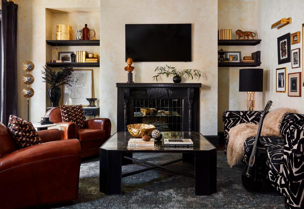 a living room with a fireplace and a tv at Guild House Hotel in Philadelphia